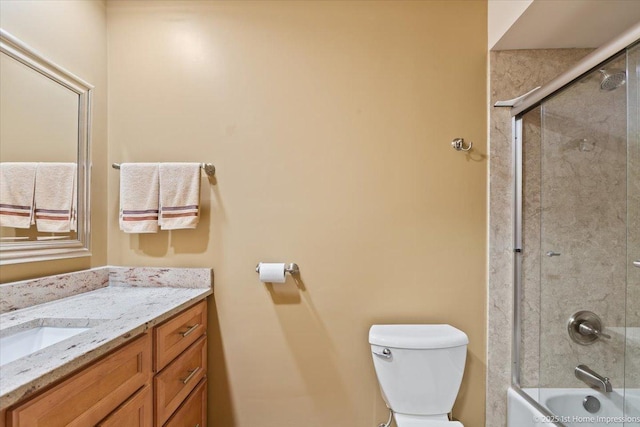 full bath featuring vanity, toilet, and shower / bath combination with glass door