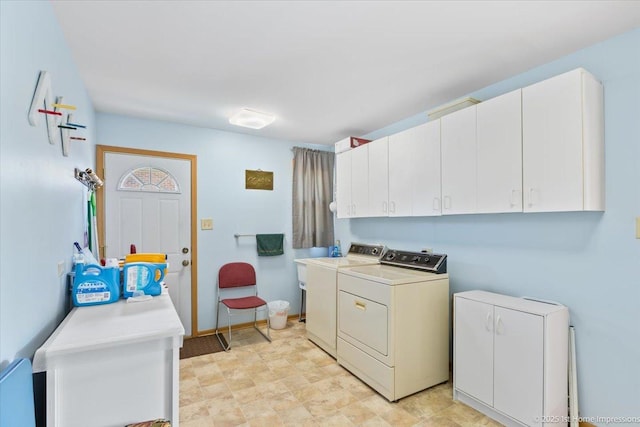 clothes washing area with cabinet space, separate washer and dryer, and baseboards