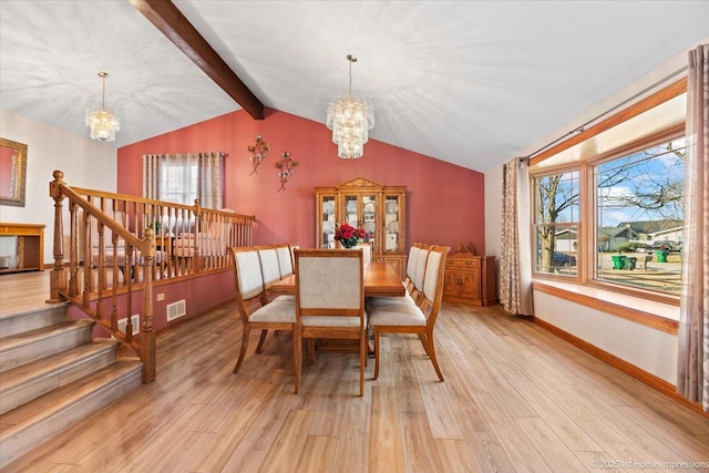 dining space with light wood-style flooring, a notable chandelier, visible vents, and vaulted ceiling with beams