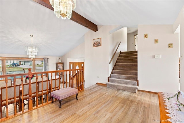 interior space with lofted ceiling with beams, stairway, a notable chandelier, and wood finished floors