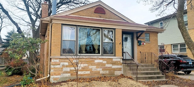 view of front of home with stone siding, brick siding, and a chimney