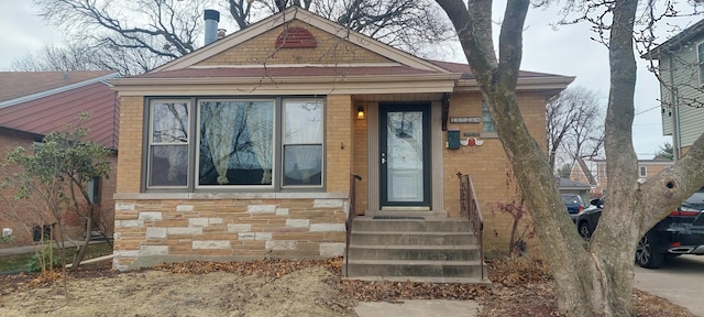 view of front of home with brick siding, stone siding, and entry steps