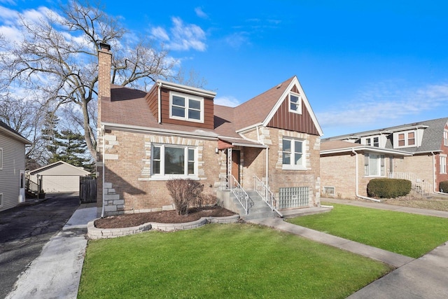 view of front facade with a chimney, an outdoor structure, a front lawn, a garage, and brick siding