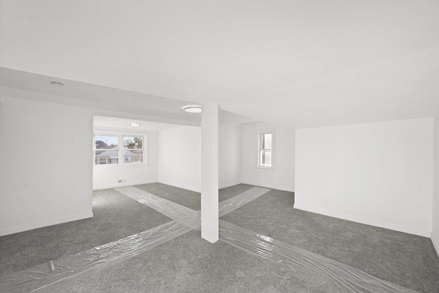 below grade area featuring a healthy amount of sunlight, baseboards, and carpet floors