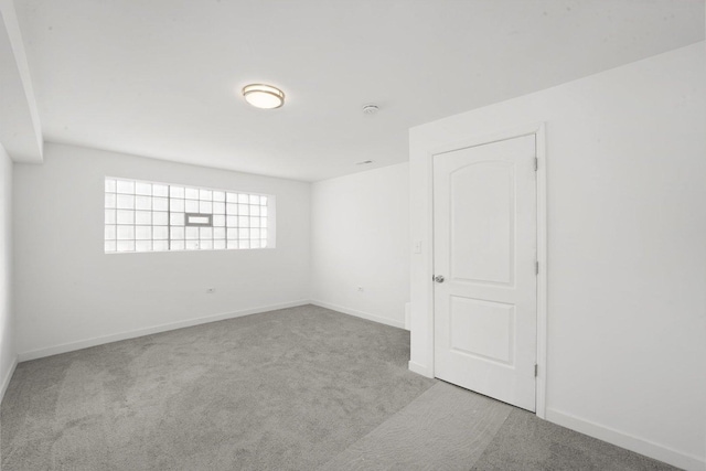 carpeted spare room featuring baseboards