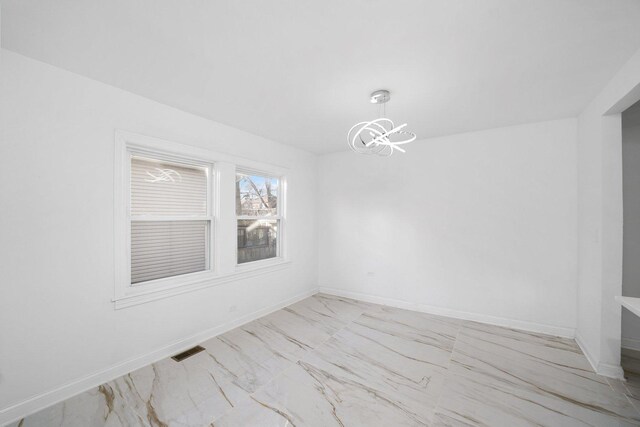 unfurnished dining area featuring a notable chandelier, baseboards, visible vents, and marble finish floor