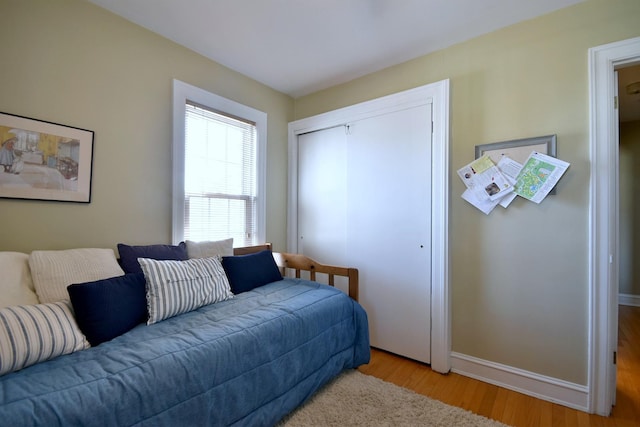 bedroom featuring a closet, baseboards, and wood finished floors