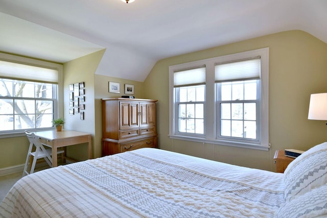 bedroom featuring multiple windows, baseboards, and lofted ceiling