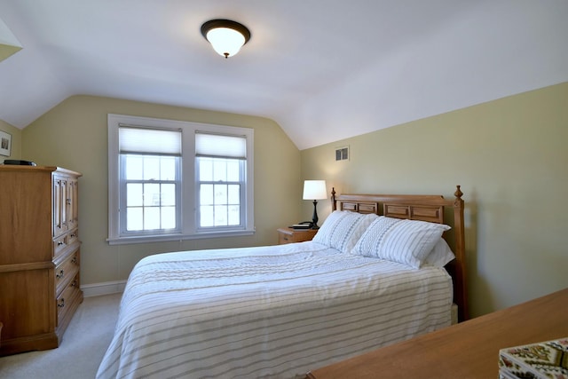 bedroom featuring visible vents, light carpet, baseboards, and vaulted ceiling