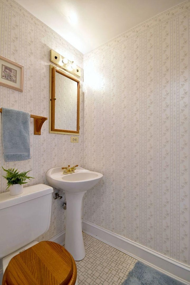 bathroom featuring wallpapered walls, toilet, and tile patterned flooring