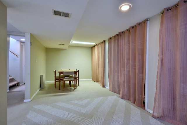 hallway featuring visible vents, carpet flooring, stairs, and baseboards