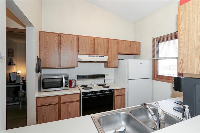 kitchen with freestanding refrigerator, a sink, range with electric cooktop, under cabinet range hood, and stainless steel microwave