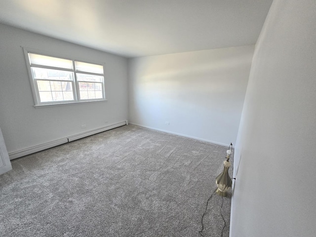 empty room featuring a baseboard heating unit, baseboards, and carpet flooring