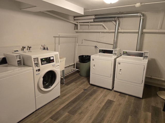 community laundry room featuring washing machine and clothes dryer and dark wood-style flooring