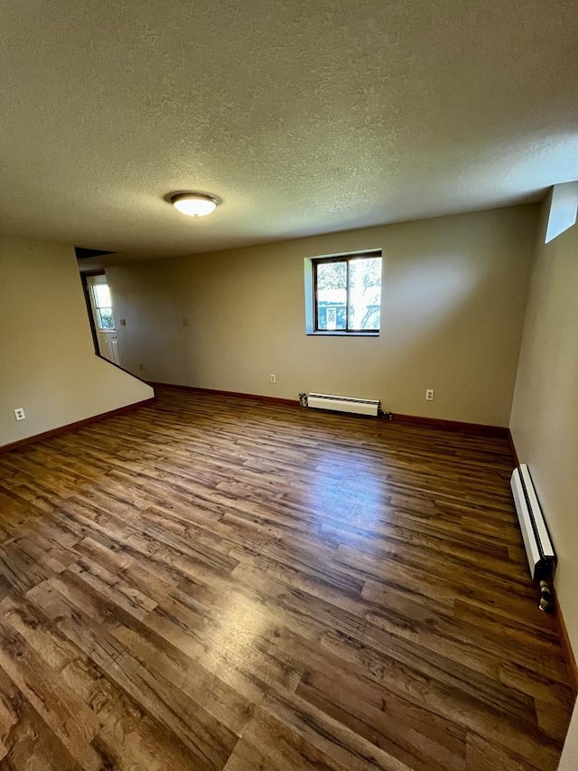 interior space with a baseboard heating unit, dark wood-style flooring, a wealth of natural light, and a baseboard radiator