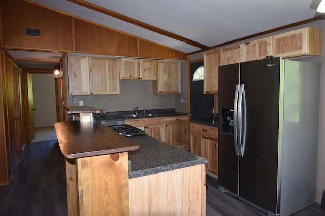 kitchen featuring a sink, stainless steel fridge, light brown cabinets, and vaulted ceiling