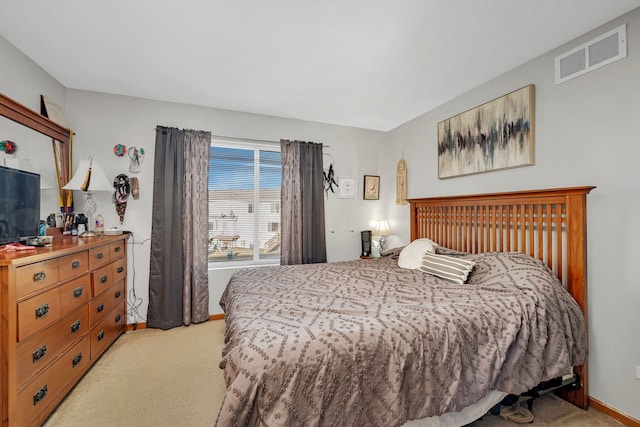 bedroom with baseboards, visible vents, and light carpet