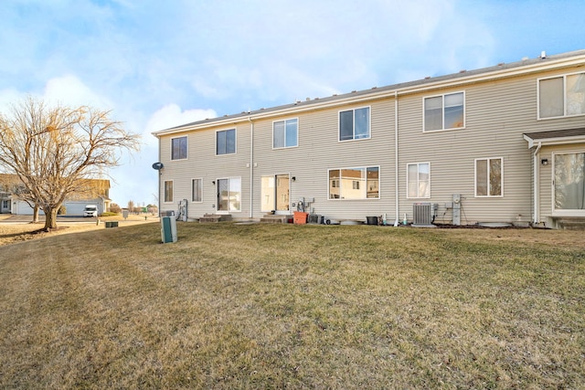 rear view of property with cooling unit and a yard