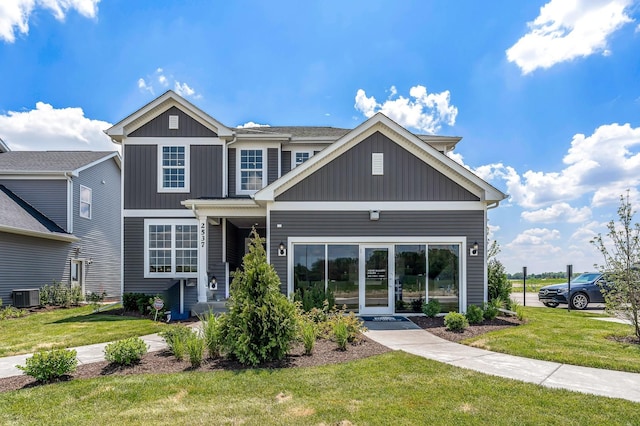 view of front of home featuring board and batten siding, central AC unit, and a front lawn