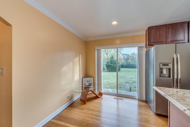 kitchen featuring light wood-type flooring, visible vents, stainless steel fridge with ice dispenser, crown molding, and baseboards