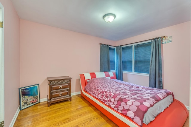 bedroom featuring baseboards and wood finished floors