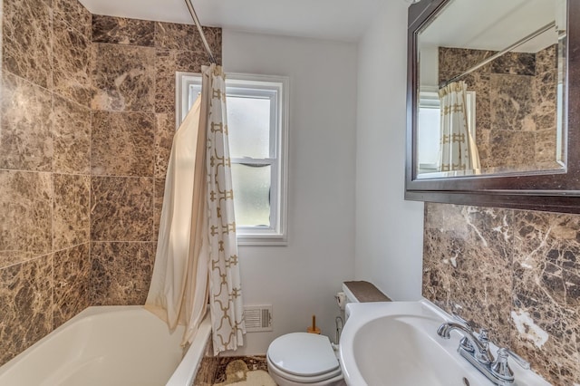 bathroom featuring a wealth of natural light, visible vents, toilet, and a sink