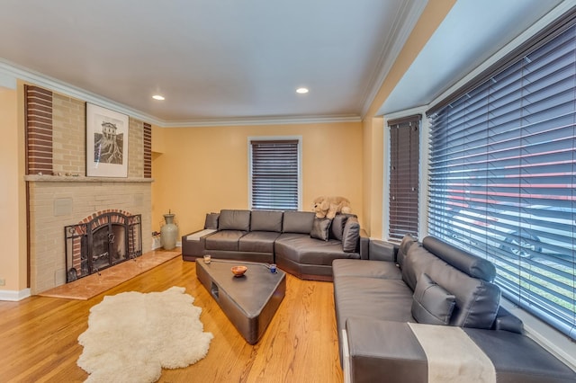 living area with recessed lighting, wood finished floors, ornamental molding, and a fireplace