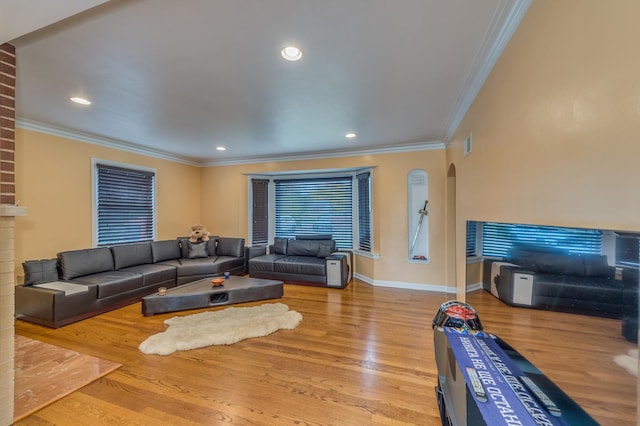 living room with baseboards, arched walkways, wood finished floors, and crown molding