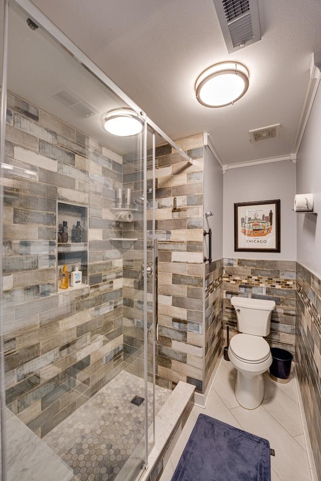 bathroom with visible vents, toilet, tile walls, and a stall shower