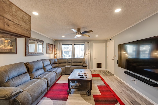 living area with wood finished floors, visible vents, recessed lighting, a textured ceiling, and crown molding