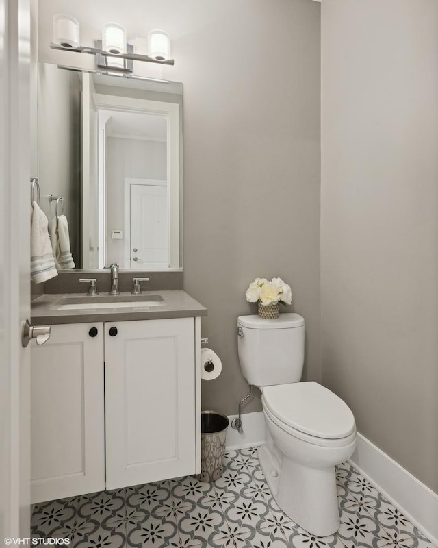 bathroom with vanity, toilet, baseboards, and tile patterned flooring