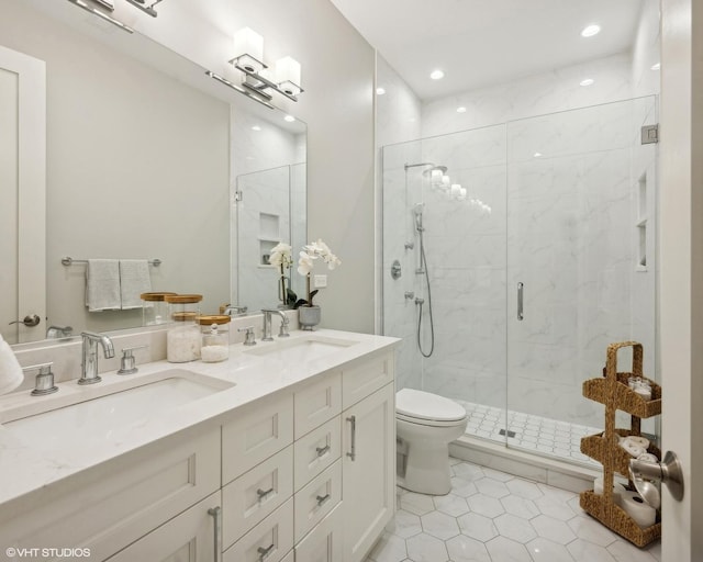 full bathroom featuring double vanity, a shower stall, toilet, and a sink