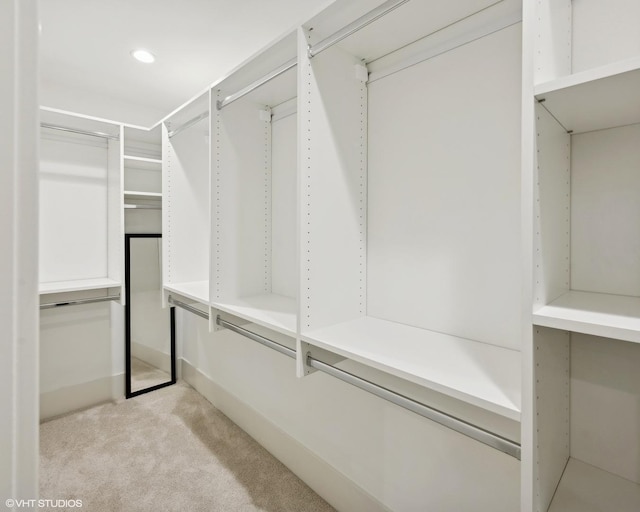 walk in closet featuring light carpet