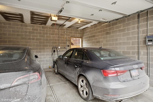 garage with concrete block wall and a garage door opener