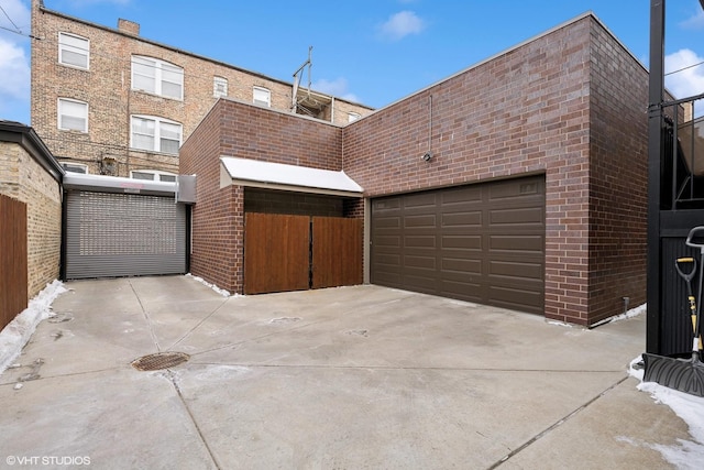 garage featuring concrete driveway and a gate