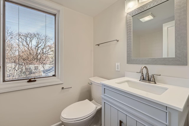 bathroom with a wealth of natural light, toilet, and vanity