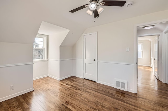 additional living space featuring visible vents, ceiling fan, baseboards, lofted ceiling, and wood finished floors