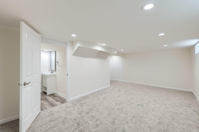 finished below grade area with recessed lighting, light colored carpet, and a sink