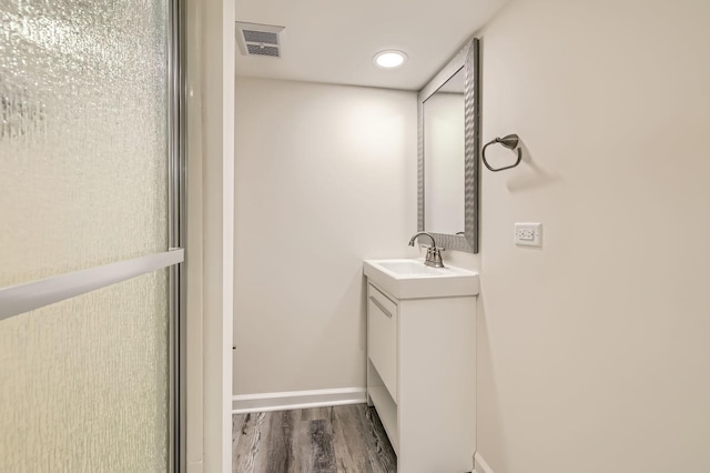 bathroom featuring visible vents, vanity, baseboards, and wood finished floors