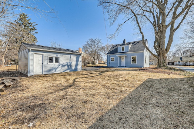 back of house featuring an outbuilding