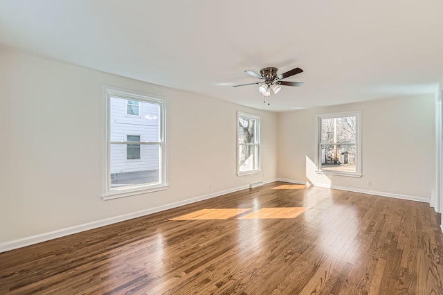 empty room with ceiling fan, baseboards, and wood finished floors