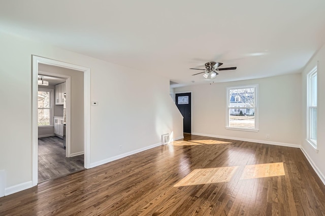 unfurnished room featuring visible vents, baseboards, and dark wood-style flooring