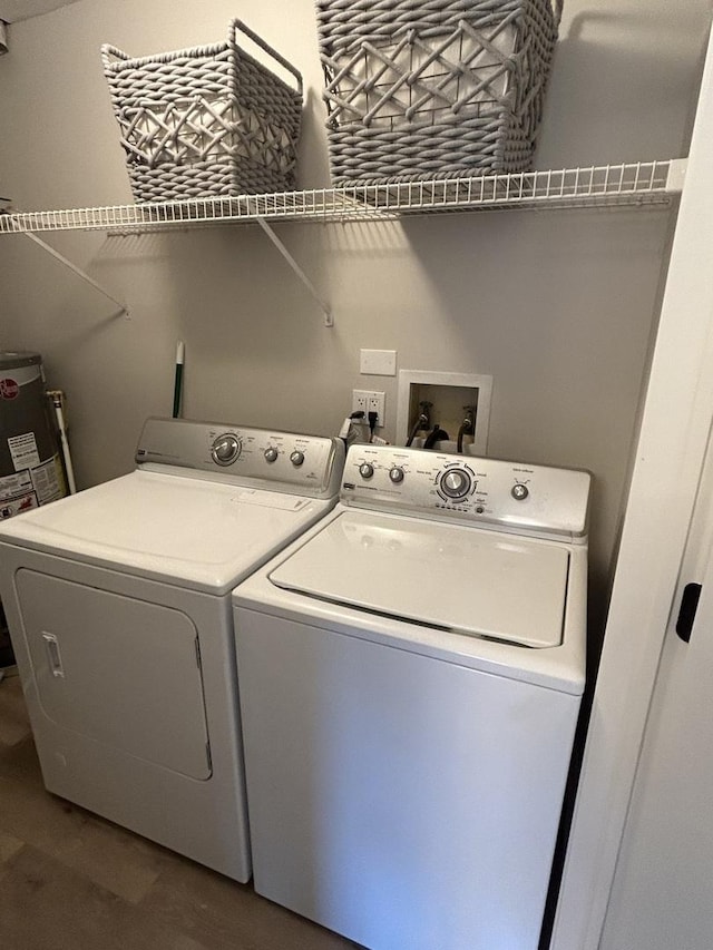 laundry area with laundry area, water heater, and washing machine and clothes dryer