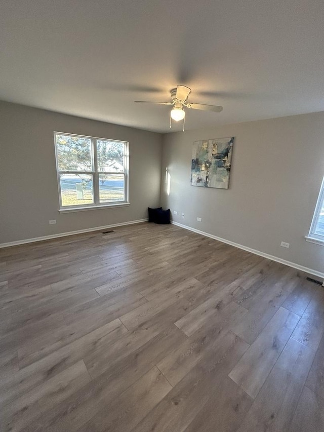 empty room with visible vents, baseboards, and dark wood-style floors