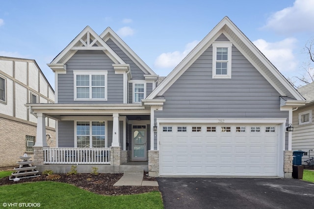 craftsman house featuring stone siding, driveway, a porch, and an attached garage