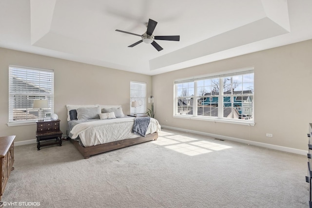 bedroom with a tray ceiling, visible vents, baseboards, and carpet floors