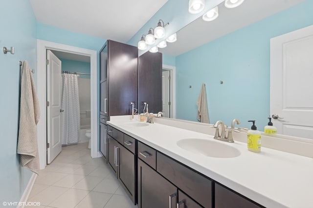 bathroom featuring tile patterned floors, double vanity, toilet, and a sink