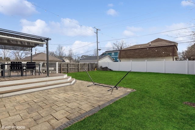 view of yard featuring a deck, a patio, and a fenced backyard