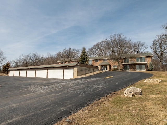 view of front of property featuring community garages and an outbuilding