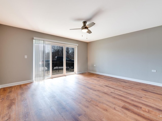 spare room featuring a ceiling fan, wood finished floors, and baseboards